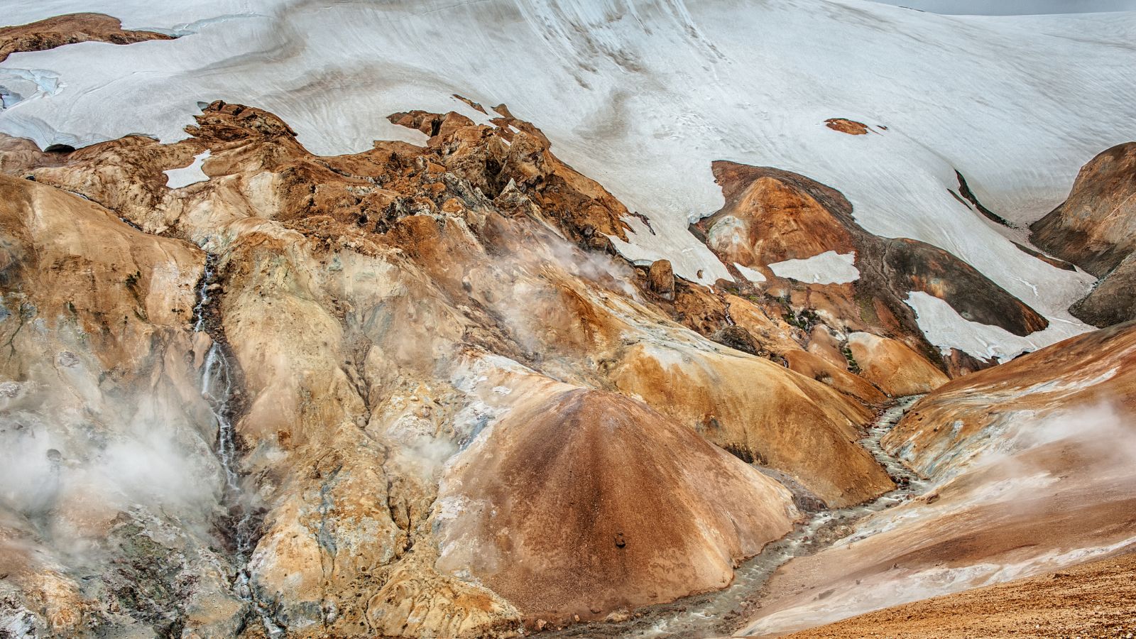 The rust-coloured Kerlingarfjöll mountain range in Iceland with steam vents.